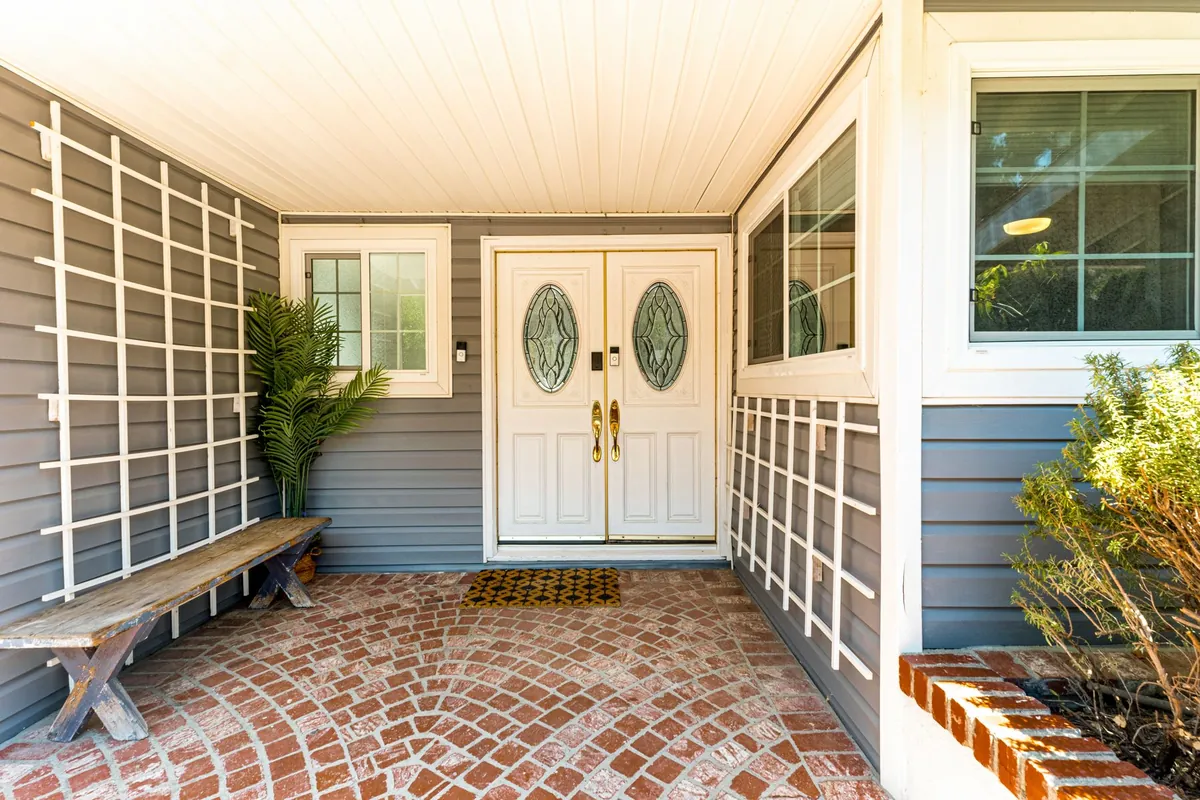 White double front doors with oval glass on a covered porch