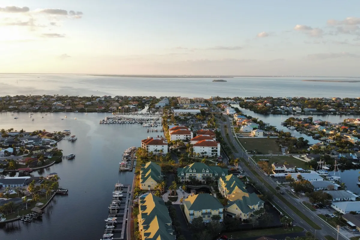 Aerial view of a canal-front waterfront community and marinas at sunset