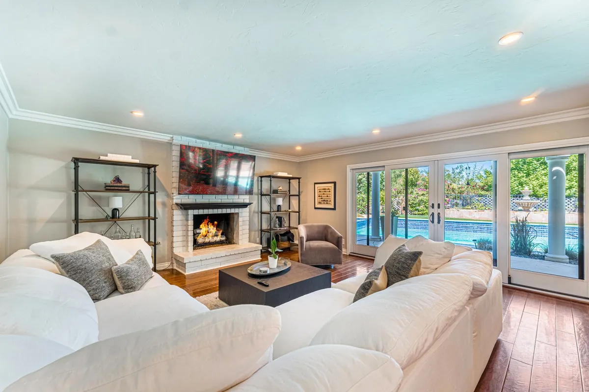 Bright living room with glass patio doors opening onto a pool